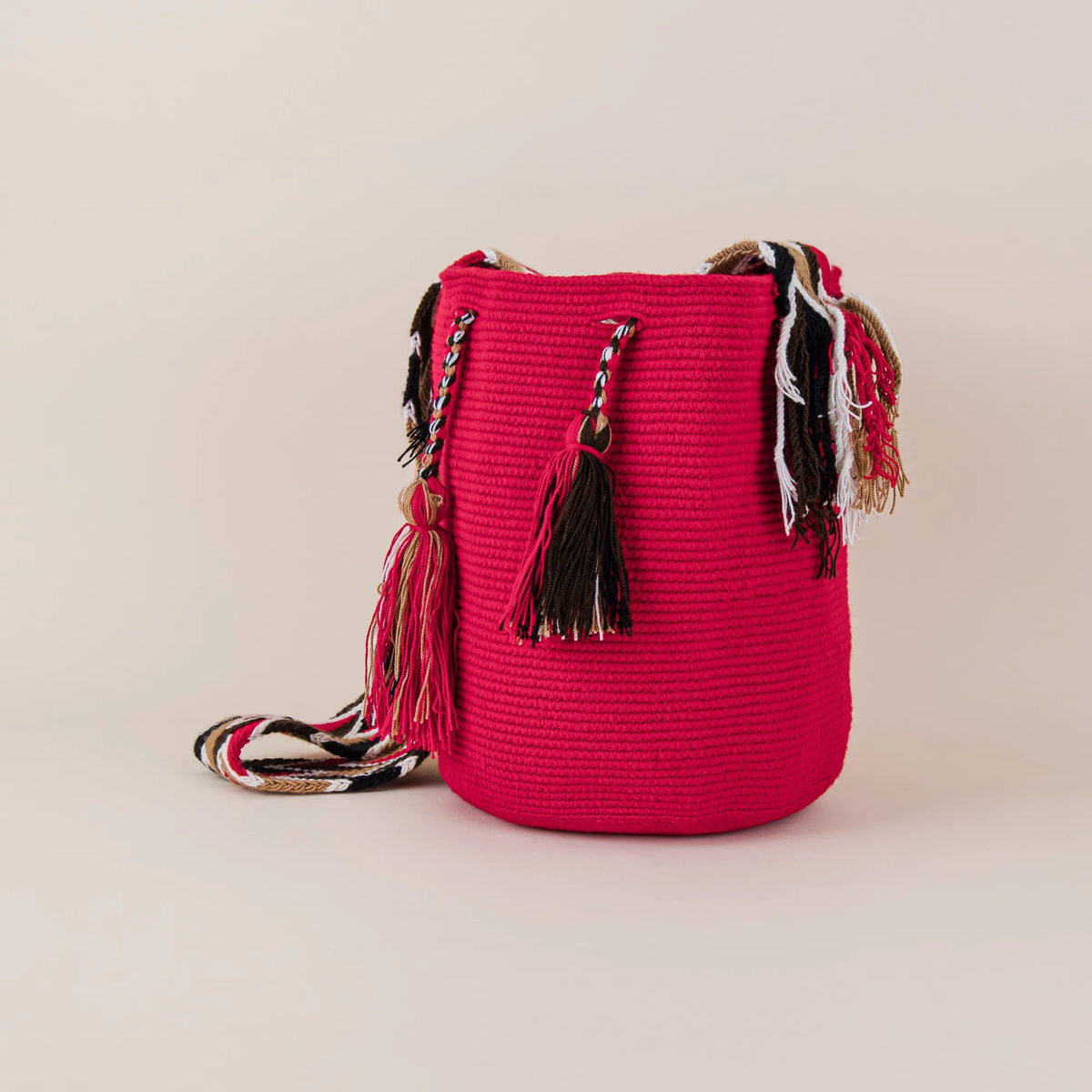 Angled view of Baranoa Wayuu Mochila featuring red handwoven body, multicolor tassels and woven shoulder strap – Maison Monserrate