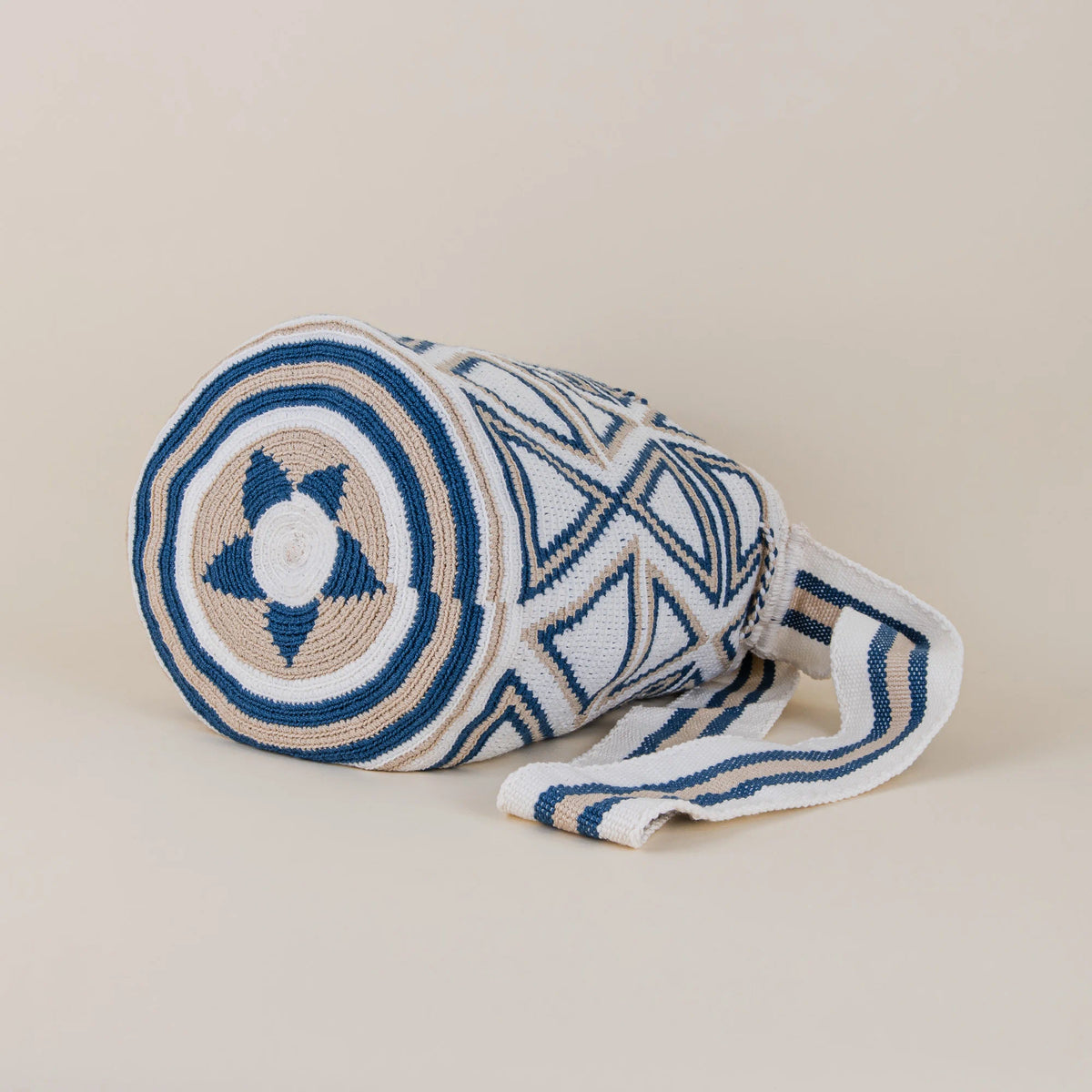 Bottom detail of Monteria Wayuu Mochila showing circular navy blue, ivory and beige handwoven pattern and woven shoulder strap – Maison Monserrate
