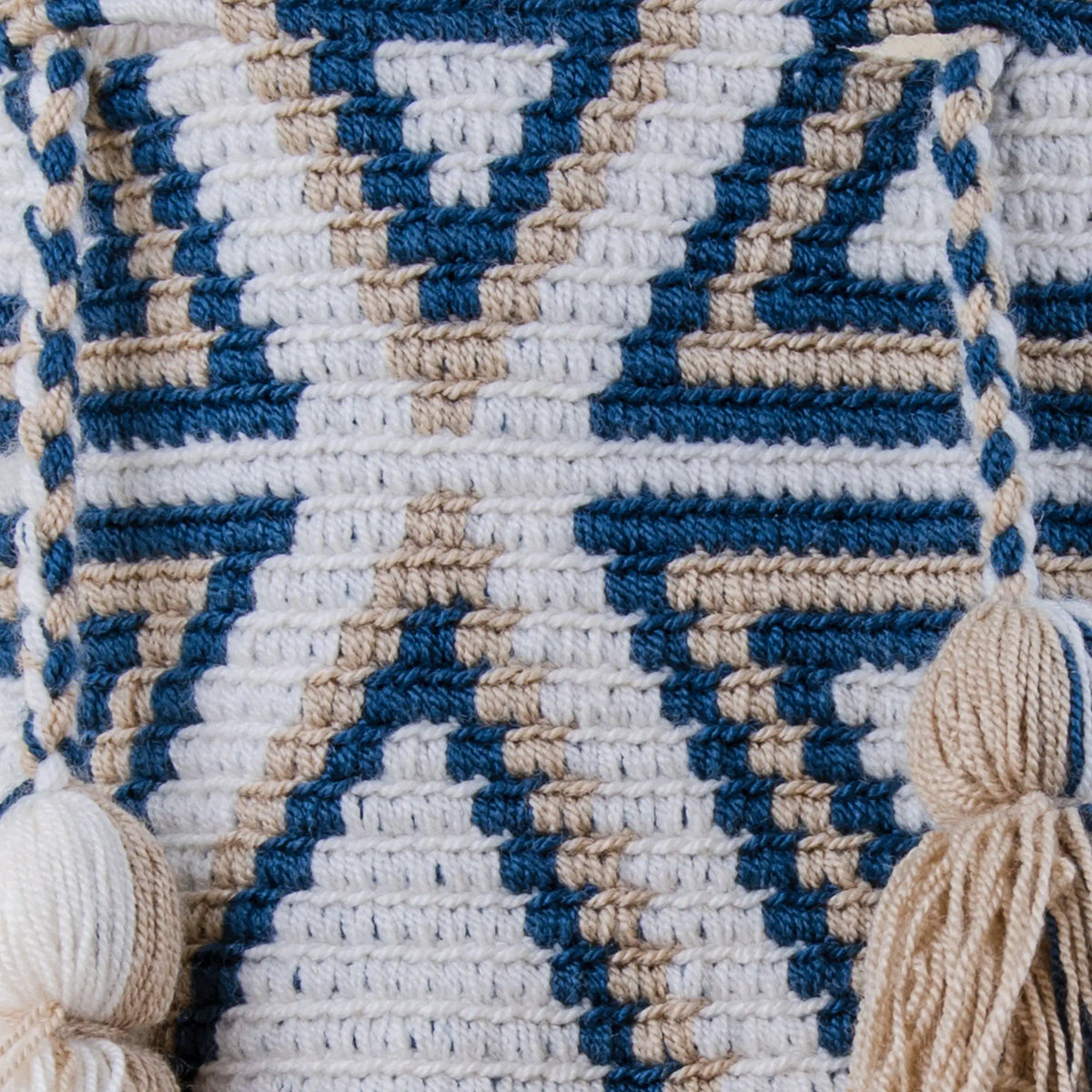 Close-up of Monteria Wayuu Mochila showing detailed geometric weaving and handcrafted tassels in navy blue, ivory and beige – Maison Monserrate